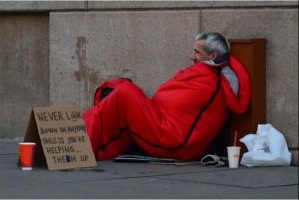 homeless man in sleeping bag on street