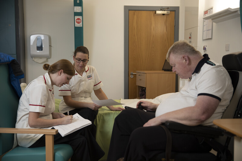 two nurses speaking to a patient