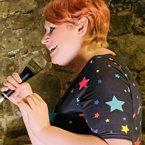 woman smiling whilst holding a microphone