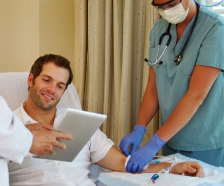 male patients being put on haemodialysis and looking at a tablet