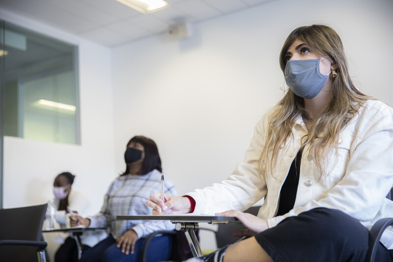 people sitting in a room wearing face masks