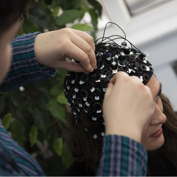 This Image shows a piece of neuroimaging equipment, used to measure brain activity, being set up on someone's head