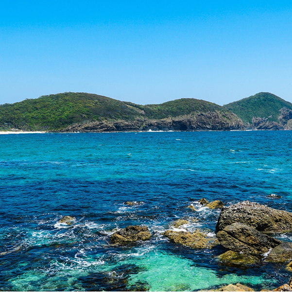 image of the sea with hills in the background