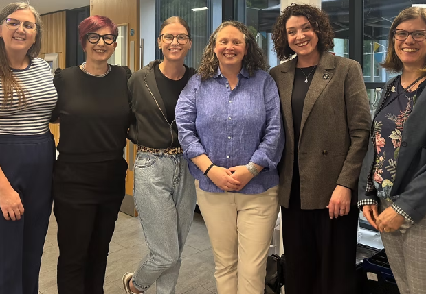 Dr Celeste Foster standing alongside attendees of the lecture