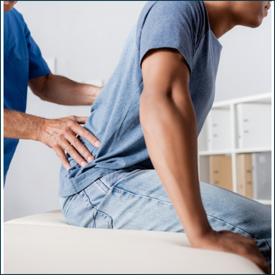 Clinician examining patient with back pain 