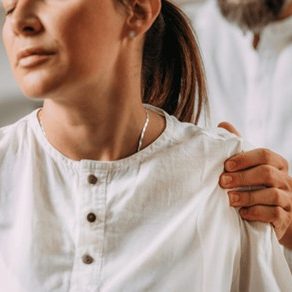 A woman being assessed for back pain by a healthcare professional
