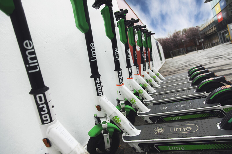 lime e-scooters lined up against a wall