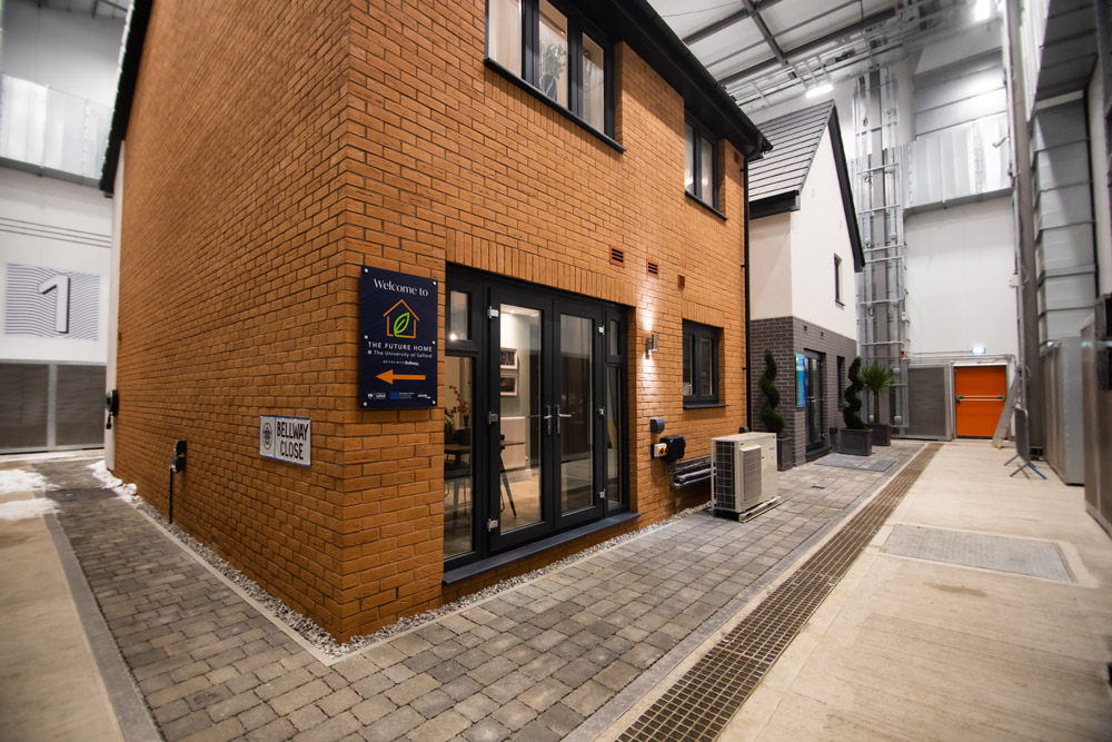 picture of a small brick house inside a sheltered building. This is the energy labs.