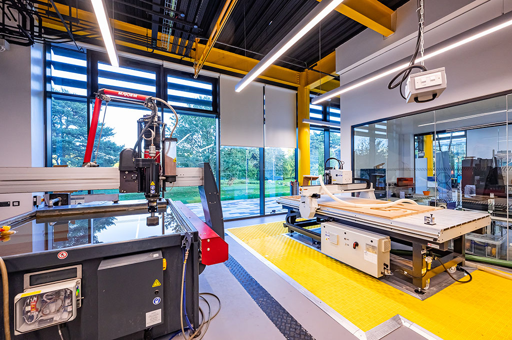 Maker space. A large spacious and brightly lit room with alot of technical hardware .
