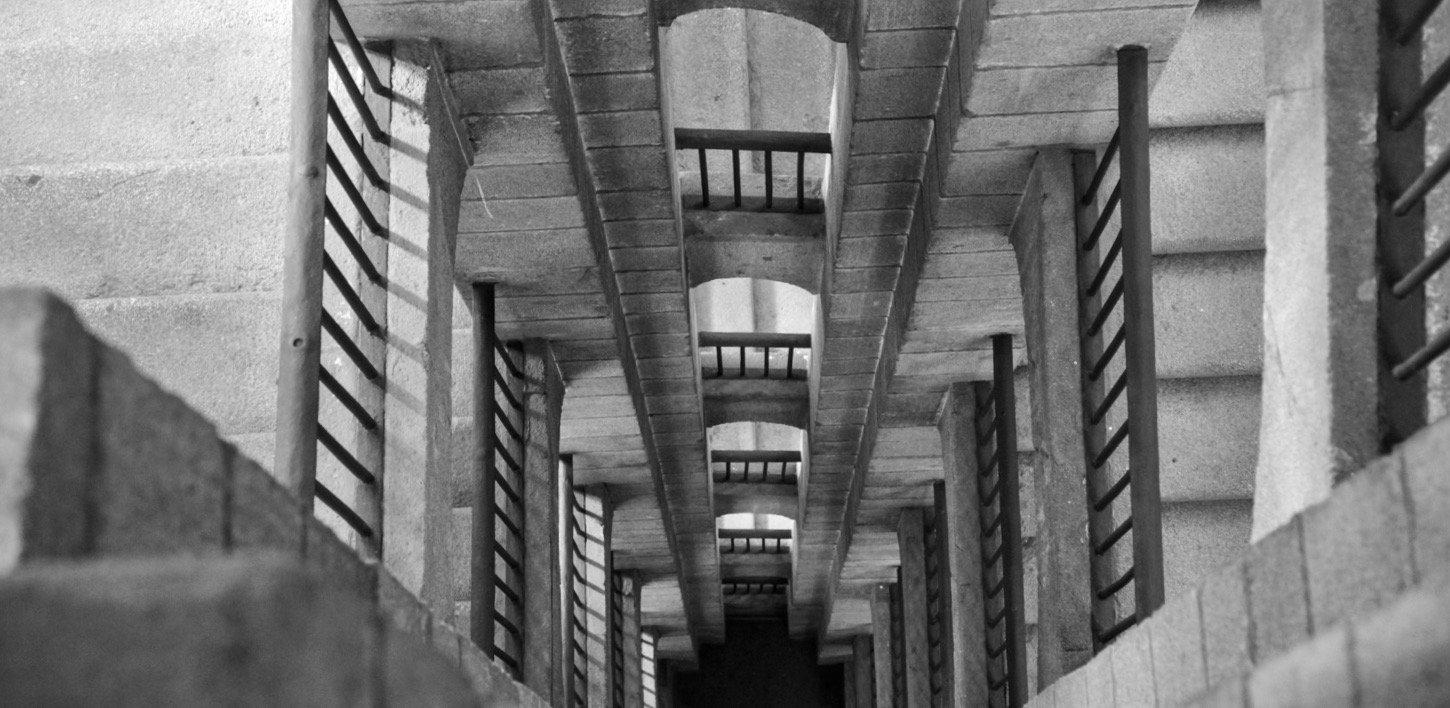 Concrete steps with wooden guards spiralling around in the shape of a square